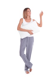 Happy woman in pajamas with pillow on white background