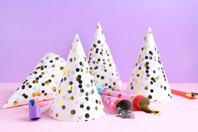 Photo of Party hats, confetti and blowers on color background