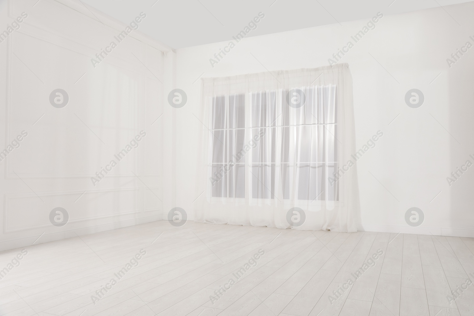 Photo of Empty room with white walls and large window