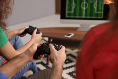 Friends playing video games at home, closeup
