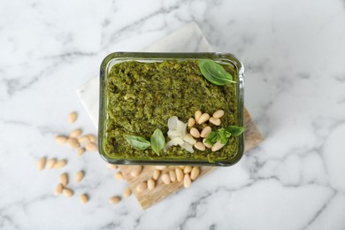 Photo of Delicious pesto sauce in bowl on white marble table, top view
