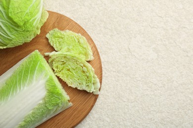 Photo of Cut fresh Chinese cabbage on light table, top view. Space for text