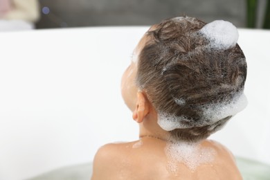 Cute little boy washing hair with shampoo in bathroom, closeup. Space for text