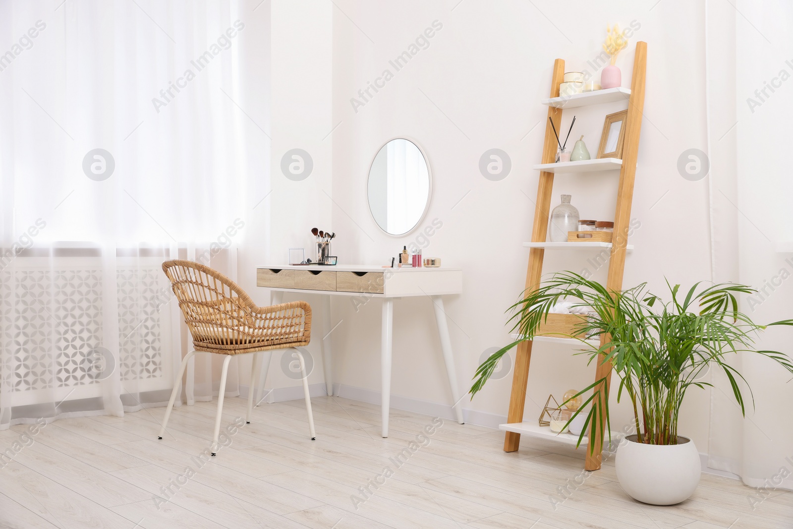 Photo of Stylish room with white dressing table, shelving unit and houseplant. Interior design