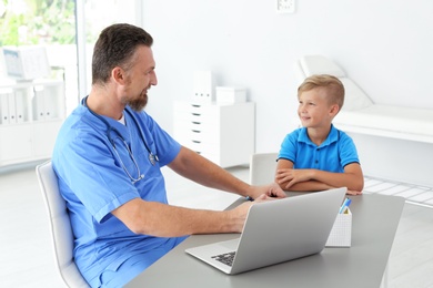 Male medical assistant consulting child in clinic