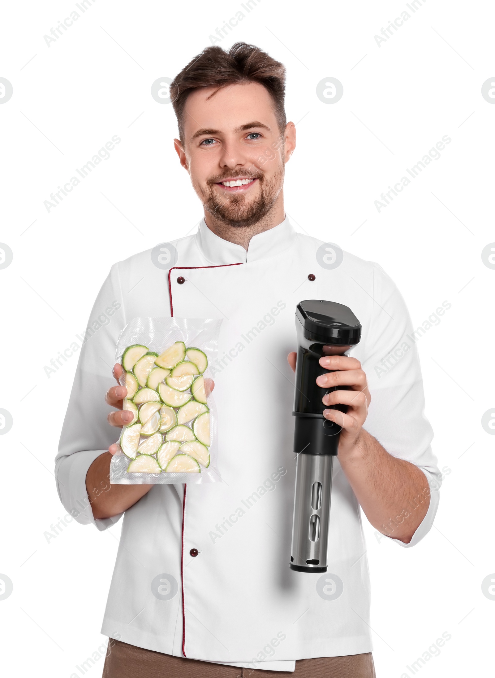 Photo of Smiling chef holding sous vide cooker and zucchini in vacuum pack on white background