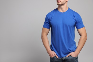 Photo of Man wearing blue t-shirt on light grey background, closeup. Mockup for design