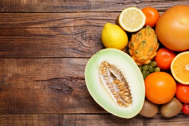 Many different fresh fruits on wooden table, flat lay. Space for text