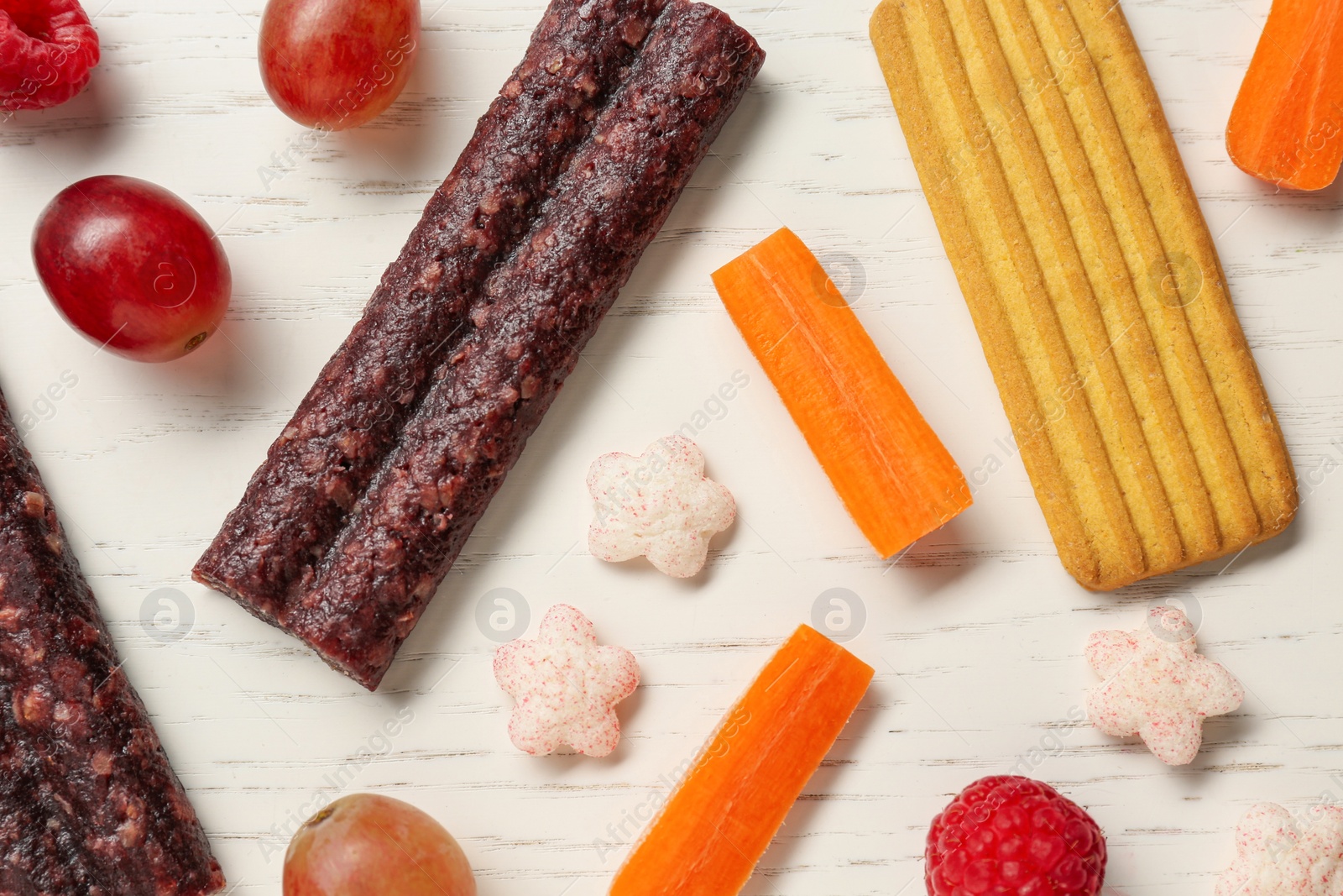 Photo of Flat lay composition with different finger foods for baby on white wooden table