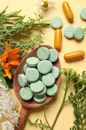 Different pills, herbs and flowers on pale orange background, flat lay. Dietary supplements