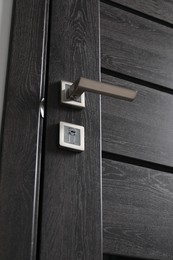 Photo of Dark wooden door with metal handle, low angle view