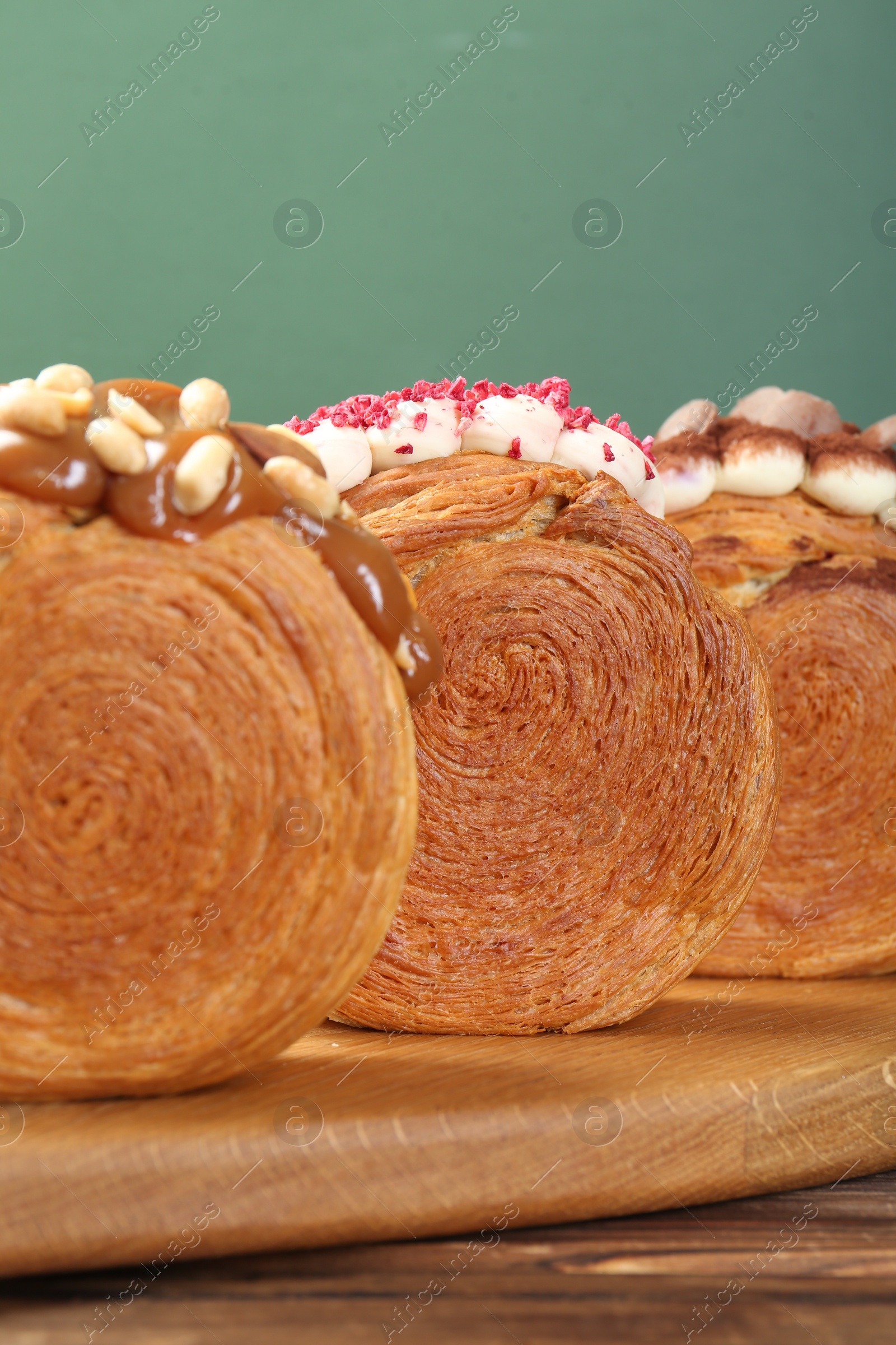 Photo of Crunchy round croissants on wooden table, closeup. Tasty puff pastry