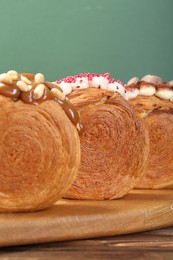 Photo of Crunchy round croissants on wooden table, closeup. Tasty puff pastry