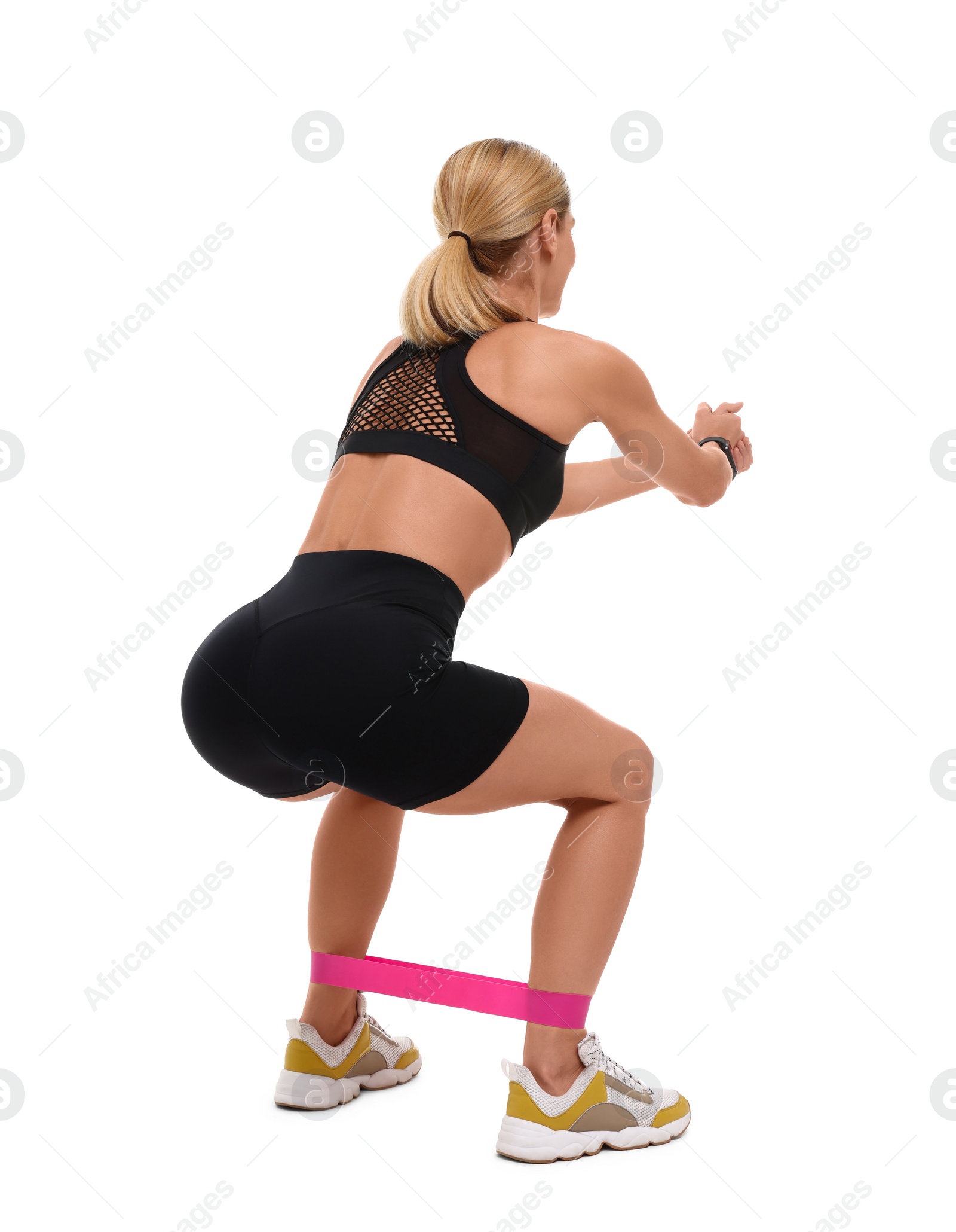 Photo of Woman exercising with elastic resistance band on white background, back view
