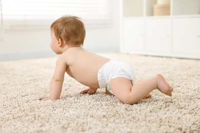 Photo of Baby boy crawling on carpet at home