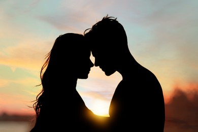Image of Silhouette of lovely couple enjoying each other at sunset