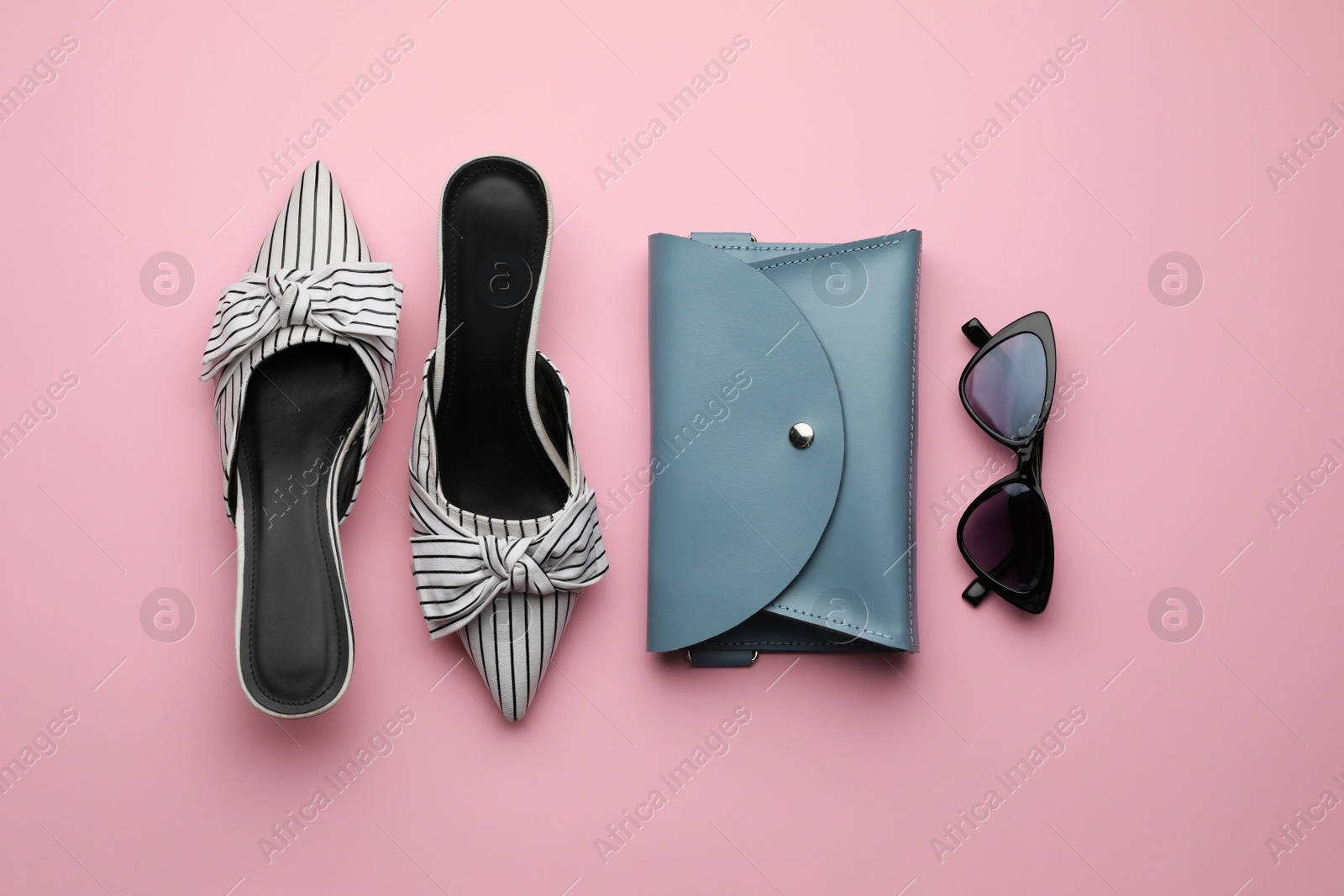 Photo of Stylish woman's bag, shoes and sunglasses on pink background, flat lay