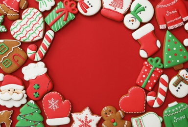 Photo of Frame made with different Christmas gingerbread cookies on red background, flat lay. Space for text