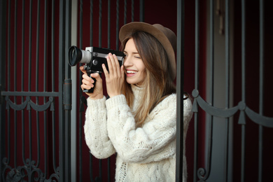 Photo of Beautiful young woman with vintage video camera outdoors