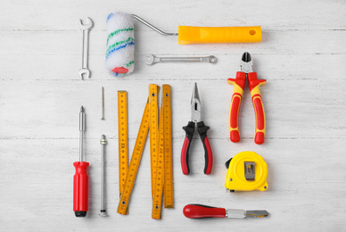 Photo of Flat lay composition with different construction tools on white wooden background