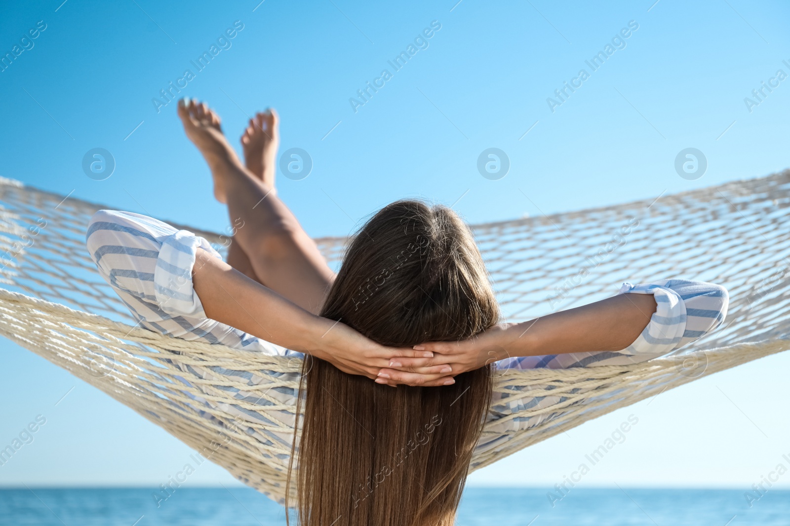 Photo of Young woman relaxing in hammock on beach