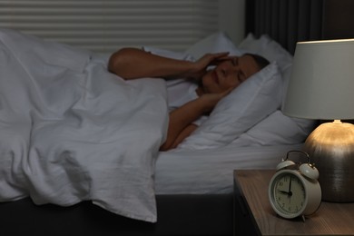 Photo of Woman suffering from headache in bed at night