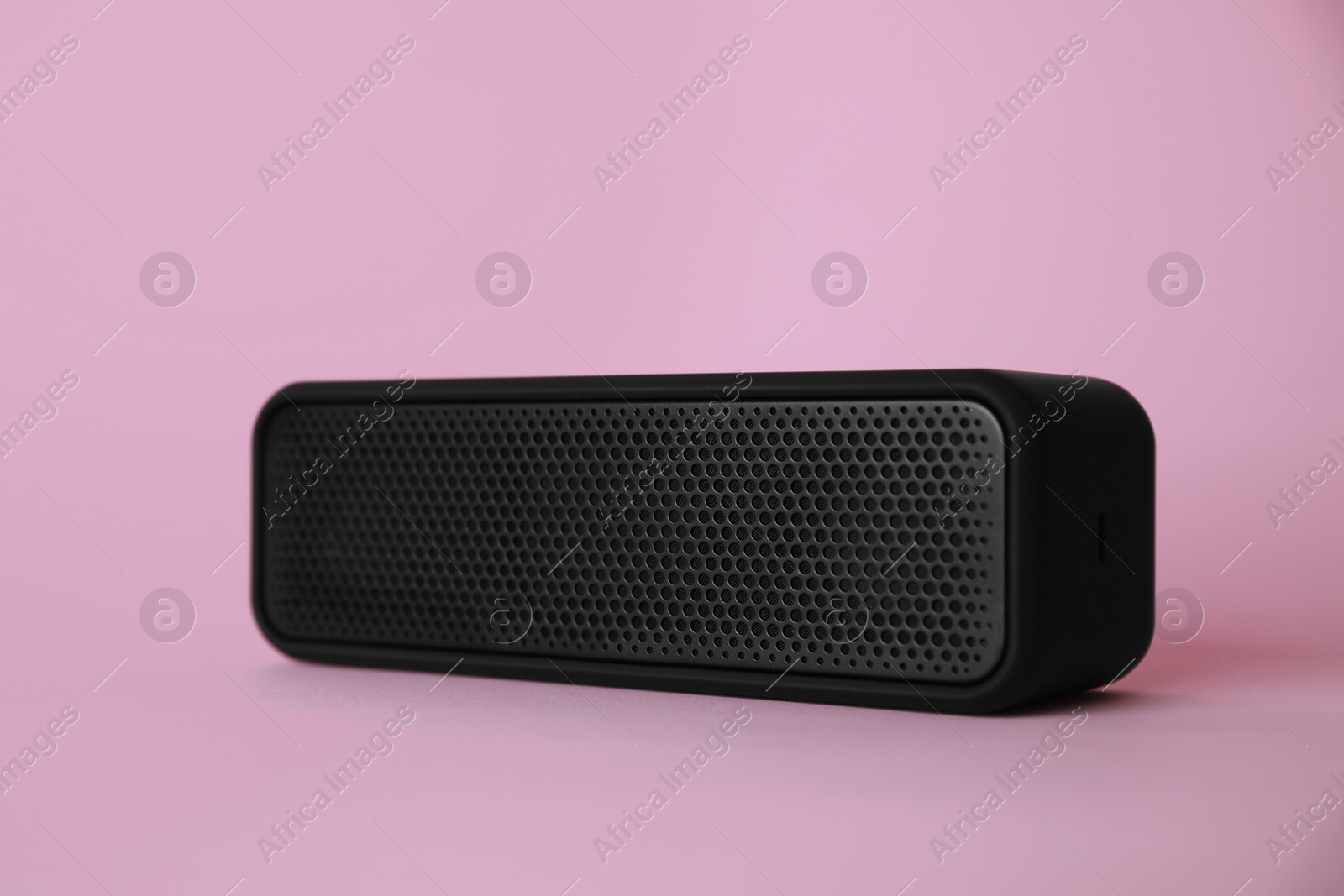 Photo of One portable bluetooth speaker on pink background. Audio equipment