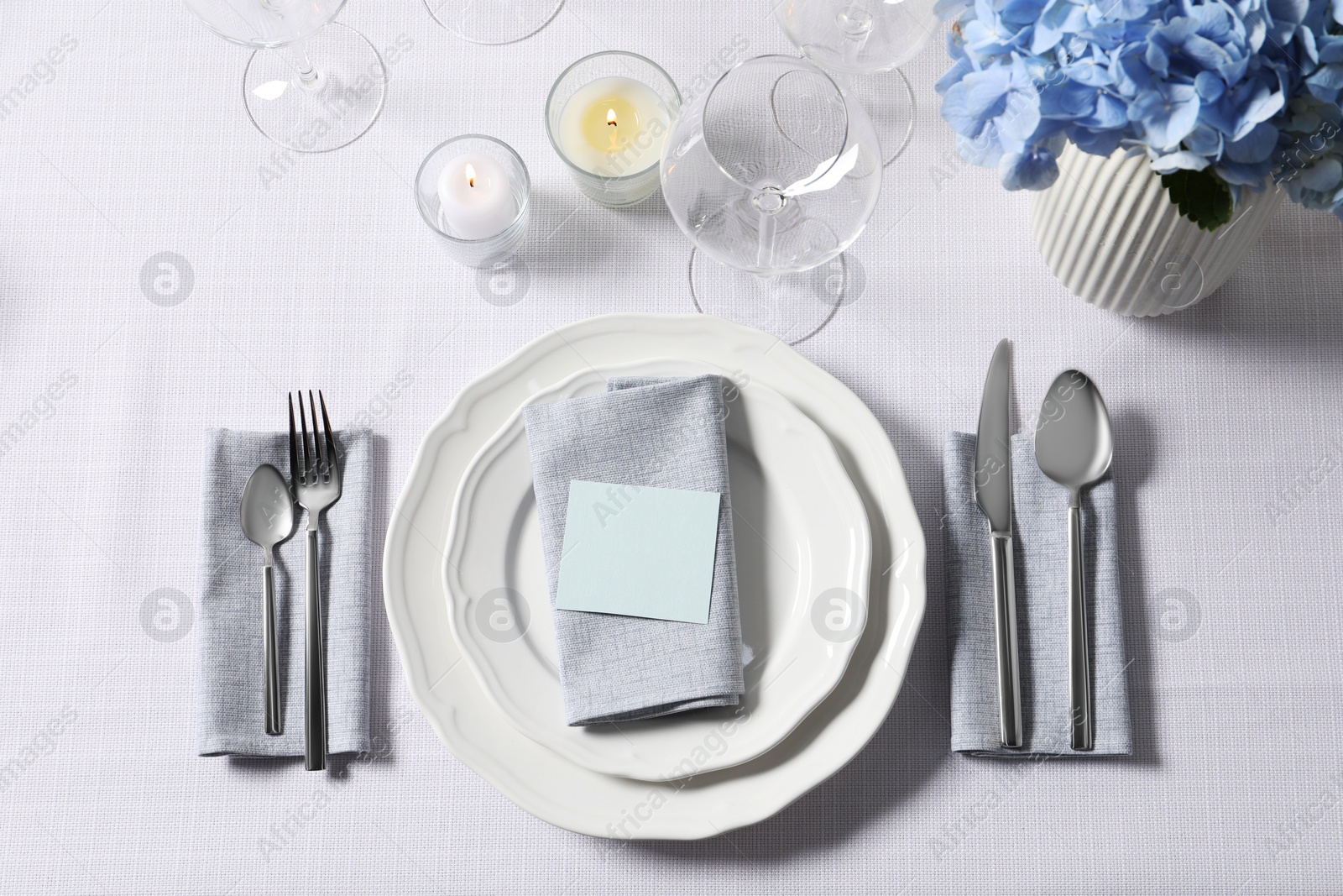 Photo of Beautiful table setting with blank card and floral decor, flat lay