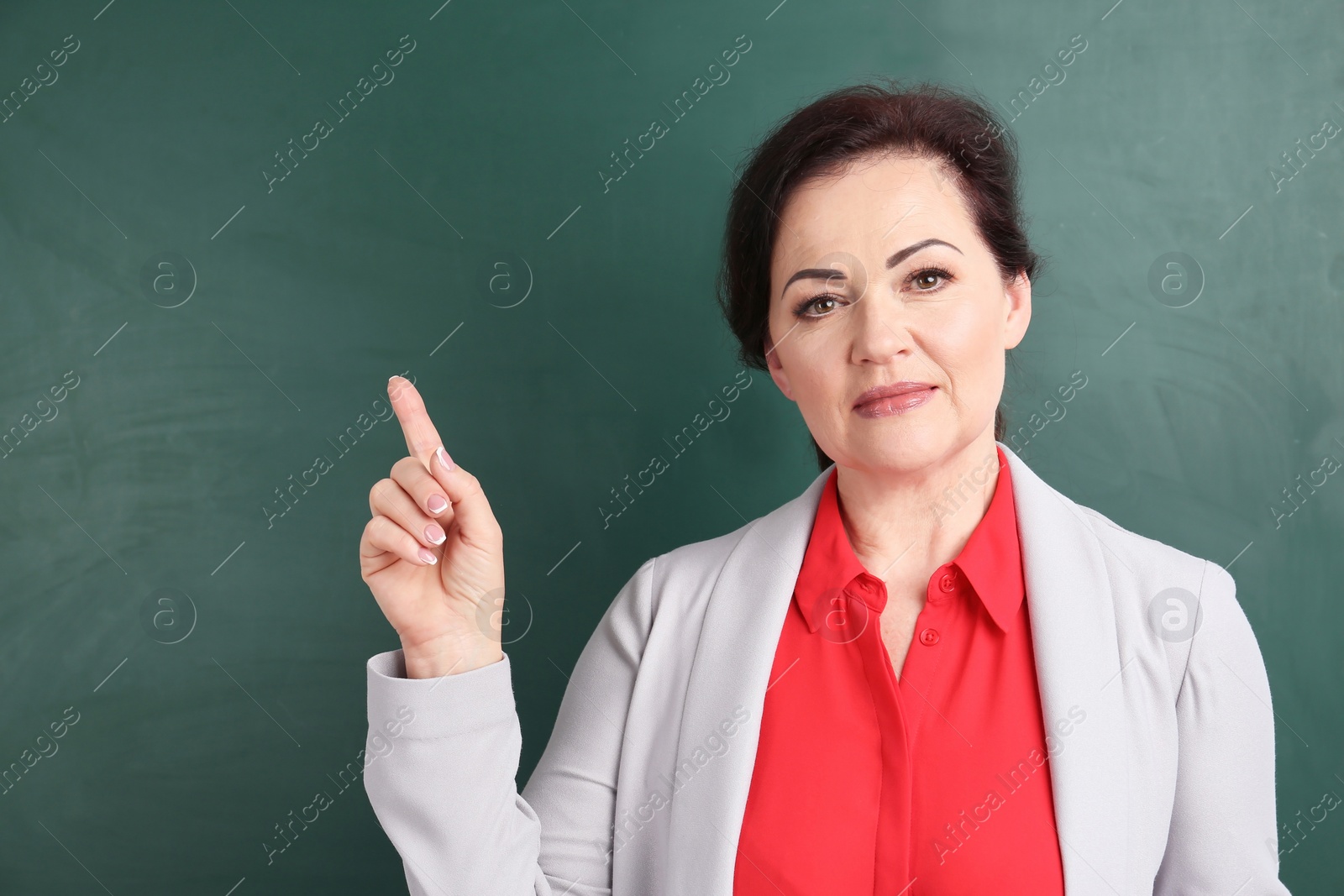 Photo of Portrait of female teacher near chalkboard