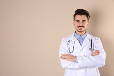 Young medical student in uniform on color background. Space for text