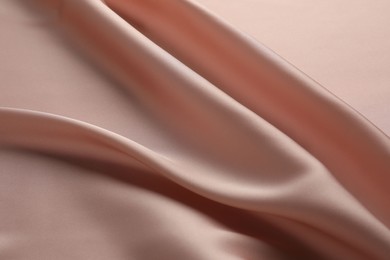 Crumpled pink silk fabric as background, top view