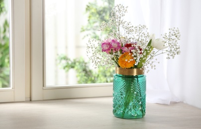 Beautiful fresh flowers on window sill indoors. Space for text