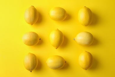 Photo of Ripe lemon fruits on yellow background, flat lay
