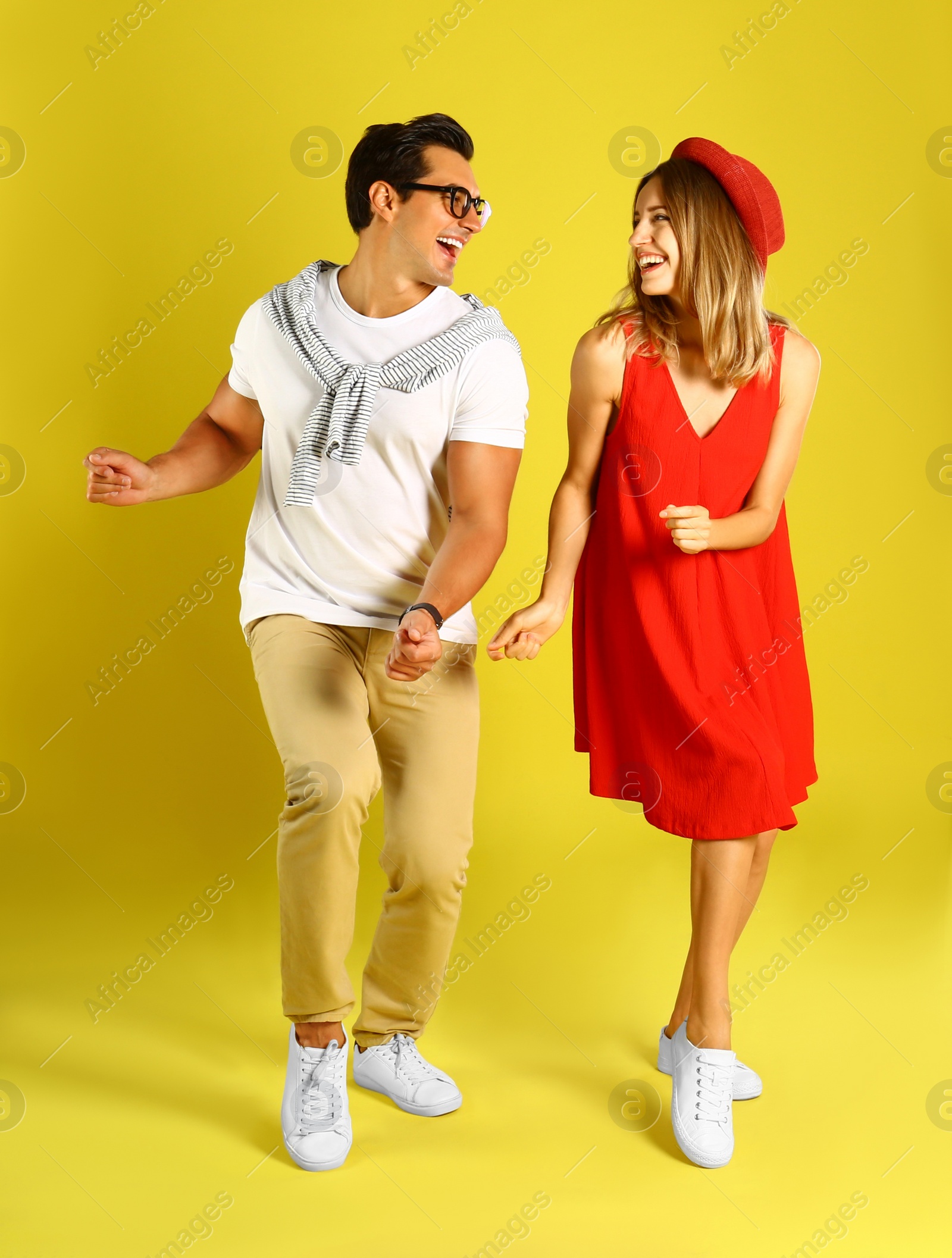 Photo of Beautiful young couple dancing on yellow background