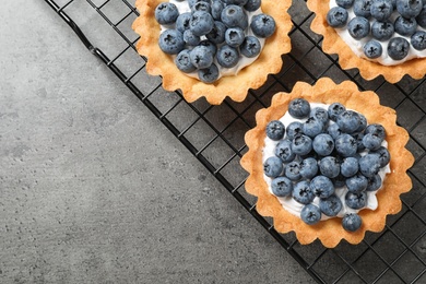 Photo of Delicious sweet pastry with berries on grey table, top view. Space for text