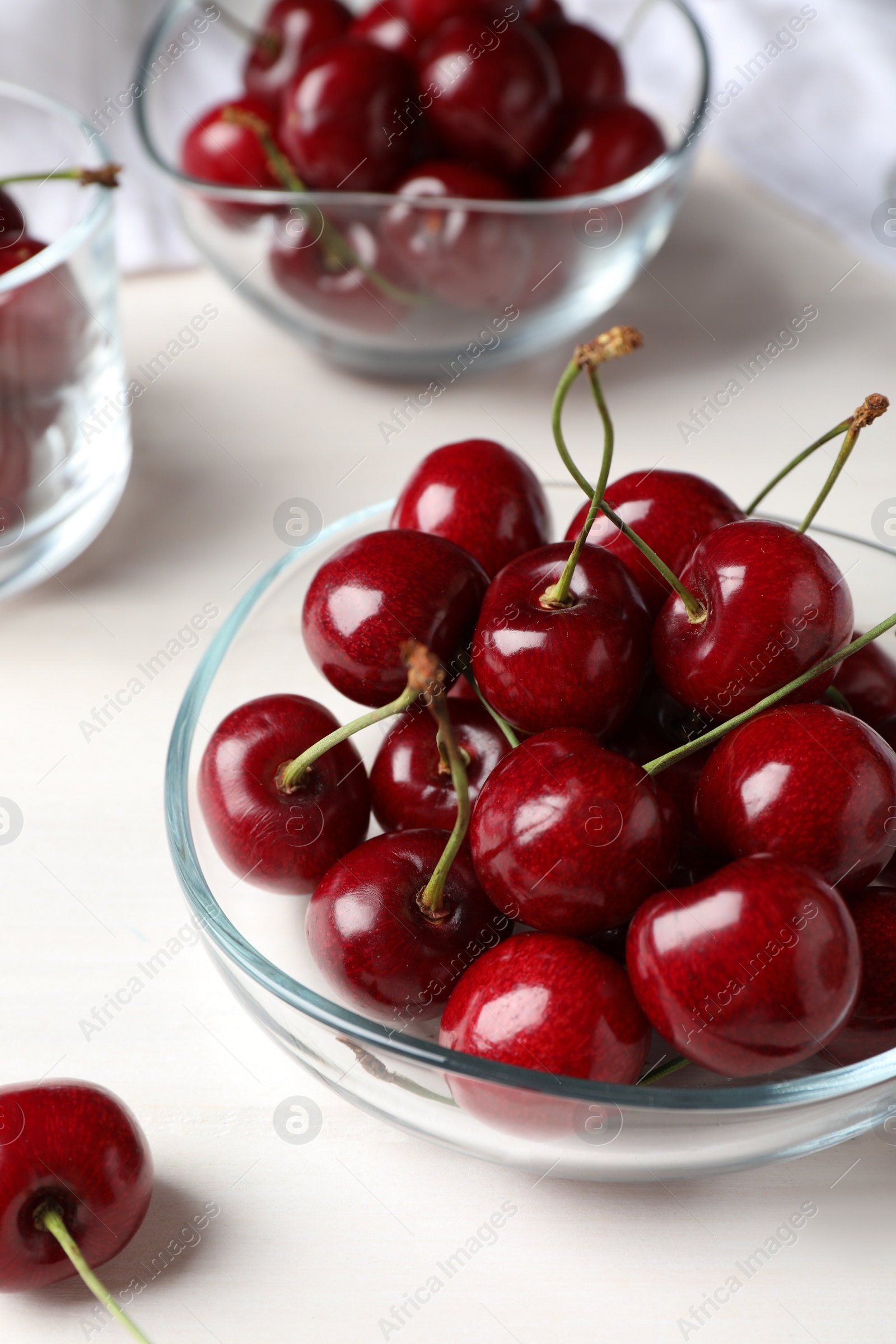 Photo of Sweet red cherries in bowl on white wooden table