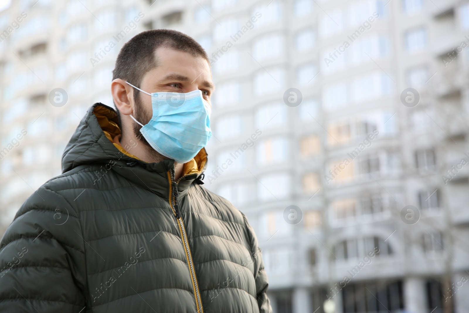 Photo of Man wearing disposable mask outdoors. Dangerous virus