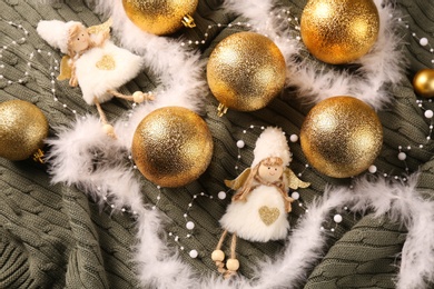 Photo of Flat lay composition with beautiful golden Christmas baubles on green knitted plaid