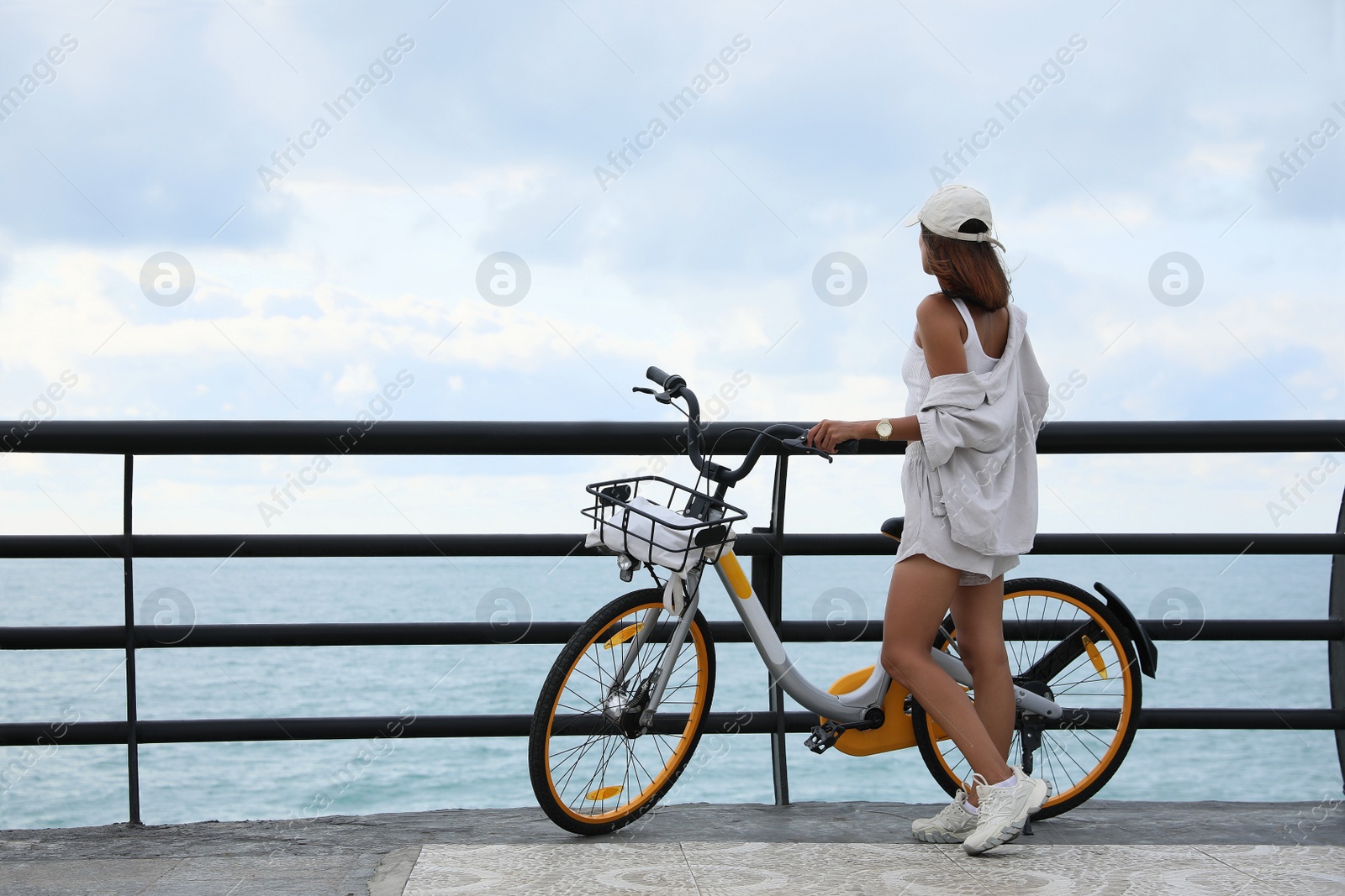 Photo of Beautiful young woman with bicycle near sea. Space for text