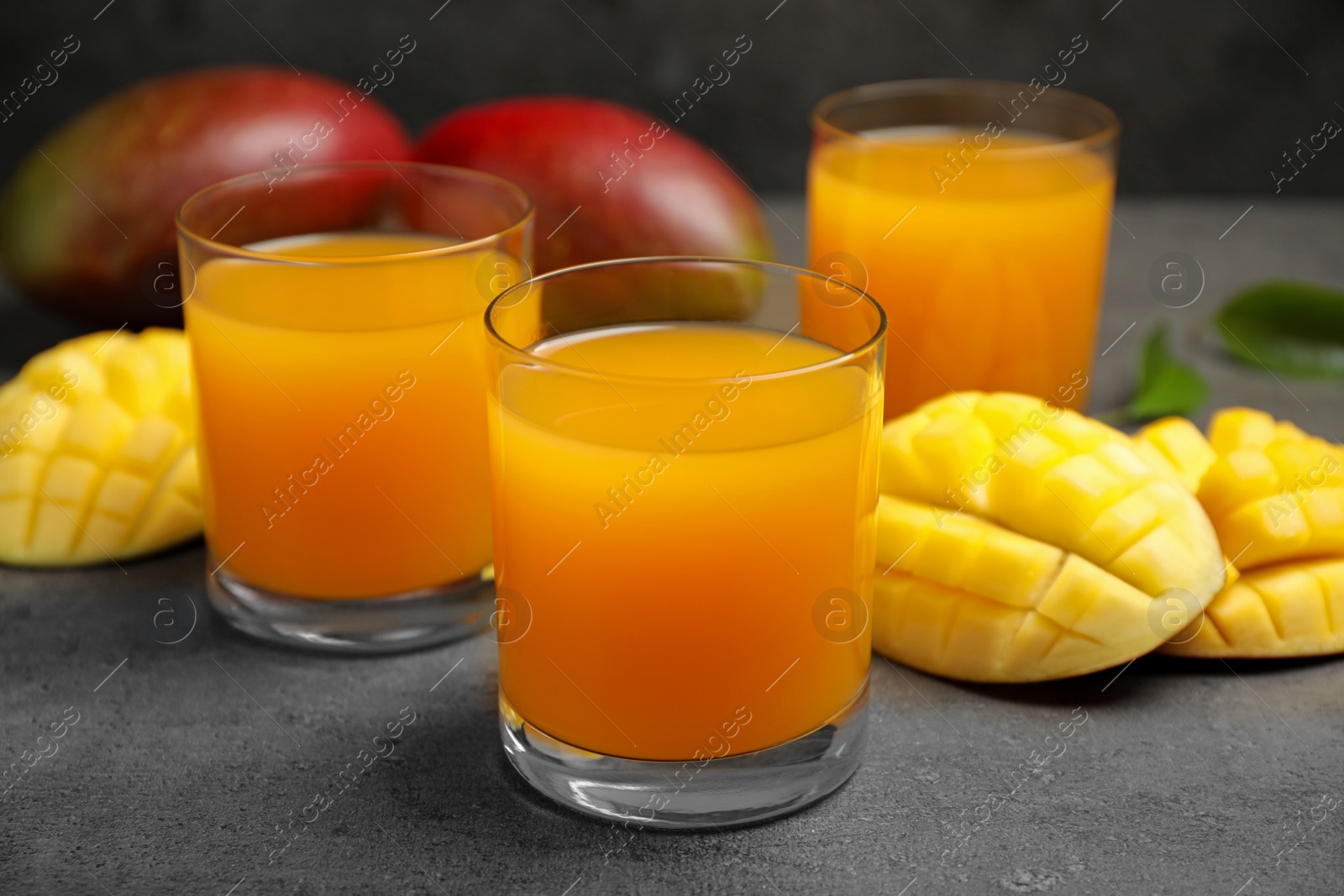 Photo of Fresh delicious mango drink on grey table