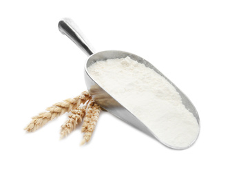 Photo of Organic flour, metal scoop and spikelets isolated on white