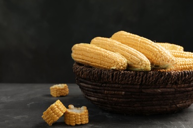 Basket with tasty sweet corn cobs on table