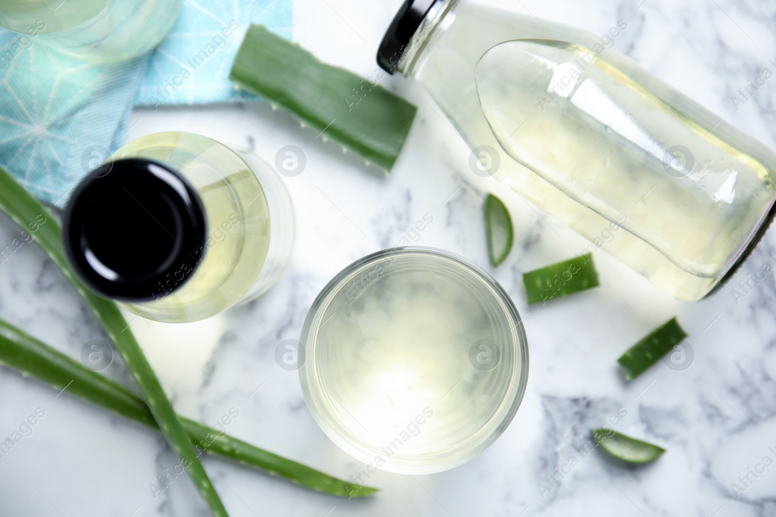 Photo of Fresh aloe drink and leaves on white marble table, flat lay