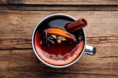 Photo of Aromatic mulled wine on wooden table, top view