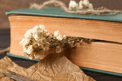 Photo of Book with flowers as bookmark on table, closeup
