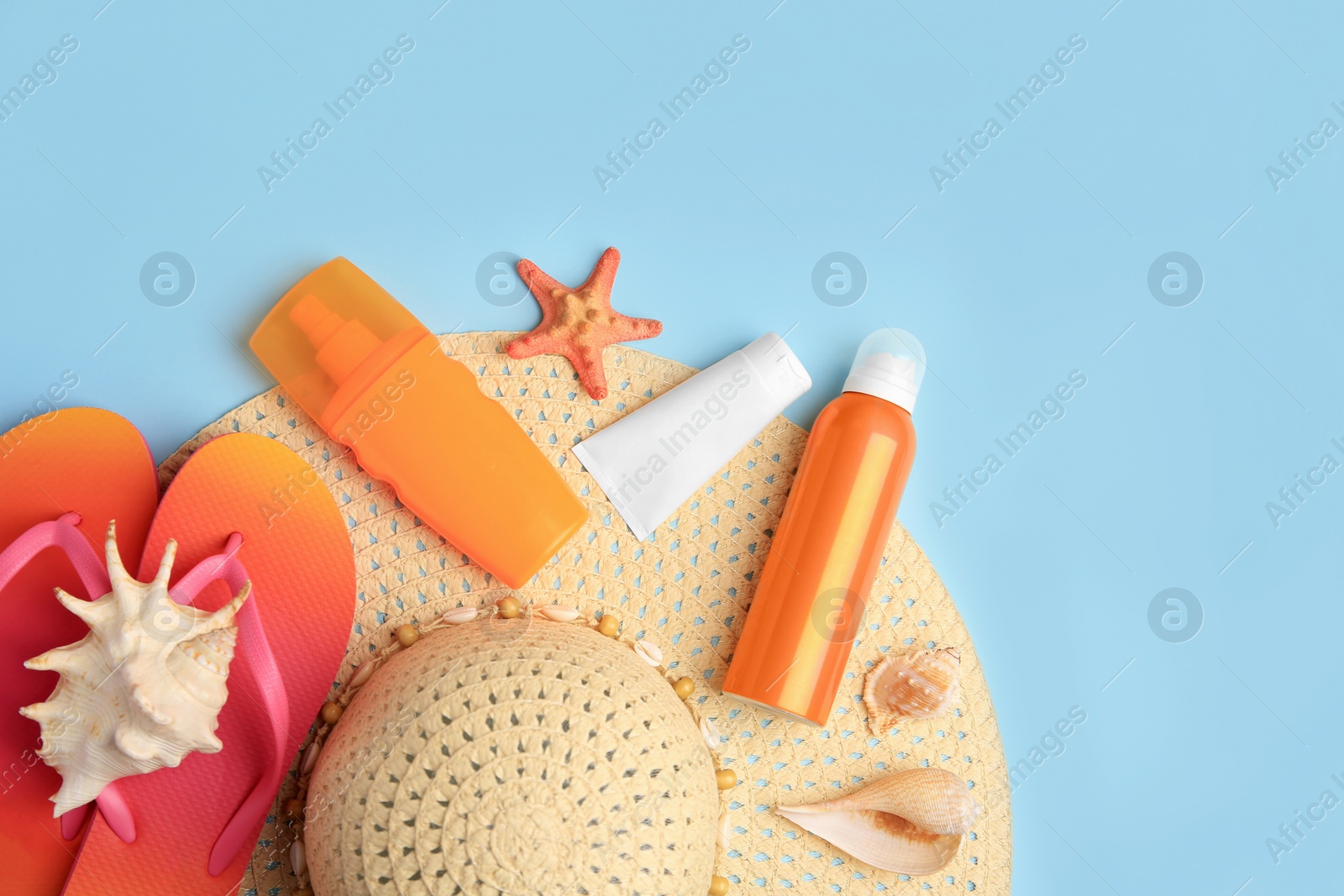 Photo of Flat lay composition with sunscreen on light blue background, space for text. Sun protection