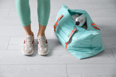 Photo of Woman with sportive bag on wooden floor, closeup
