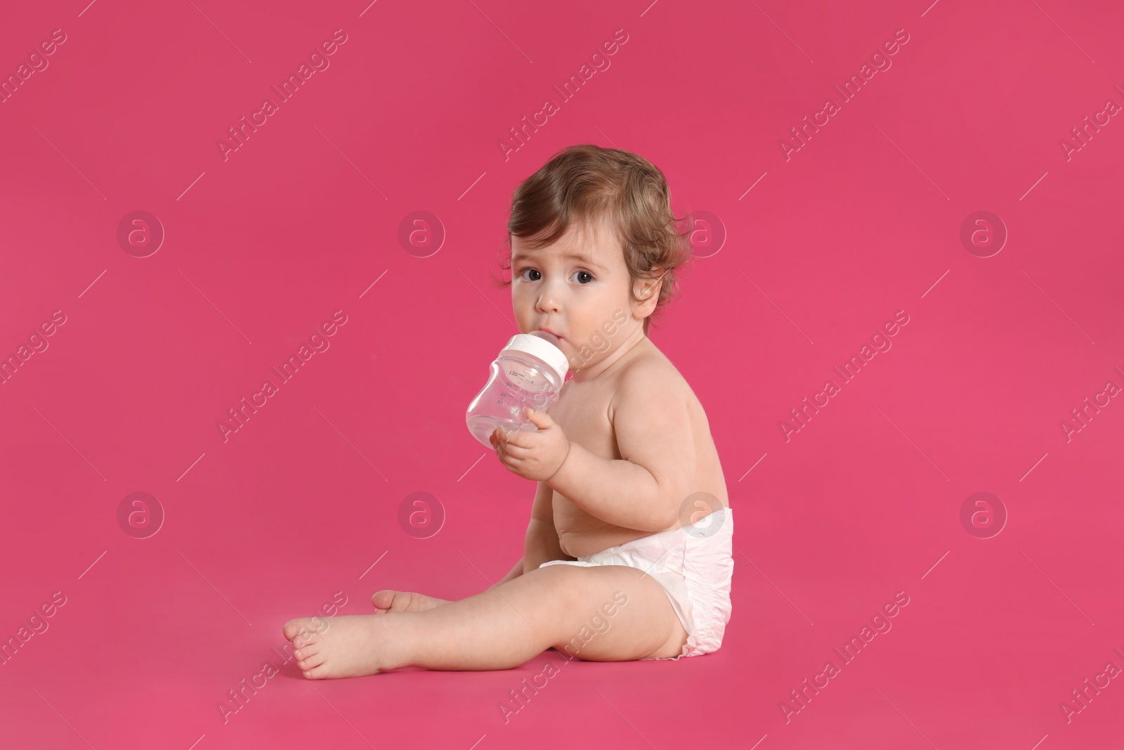 Photo of Cute little baby in diaper on pink background