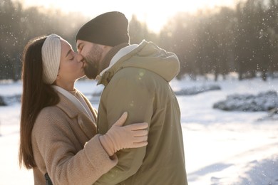 Photo of Beautiful happy couple in snowy park on winter day