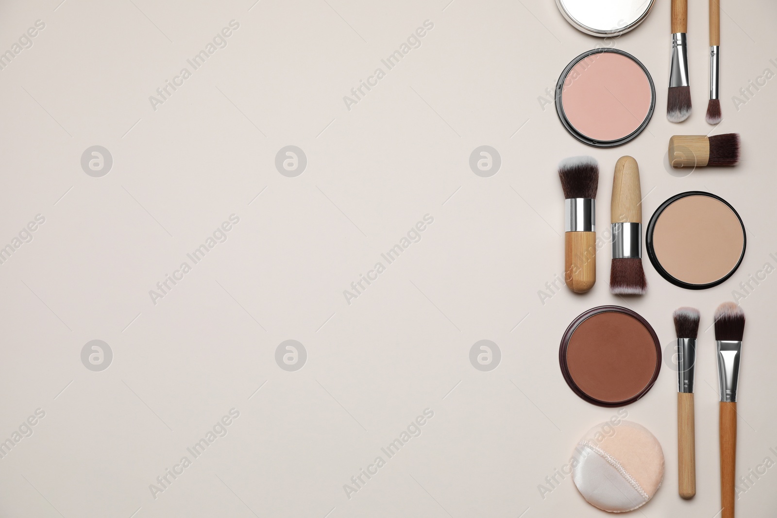 Photo of Different face powders and makeup brushes on beige background, flat lay. Space for text